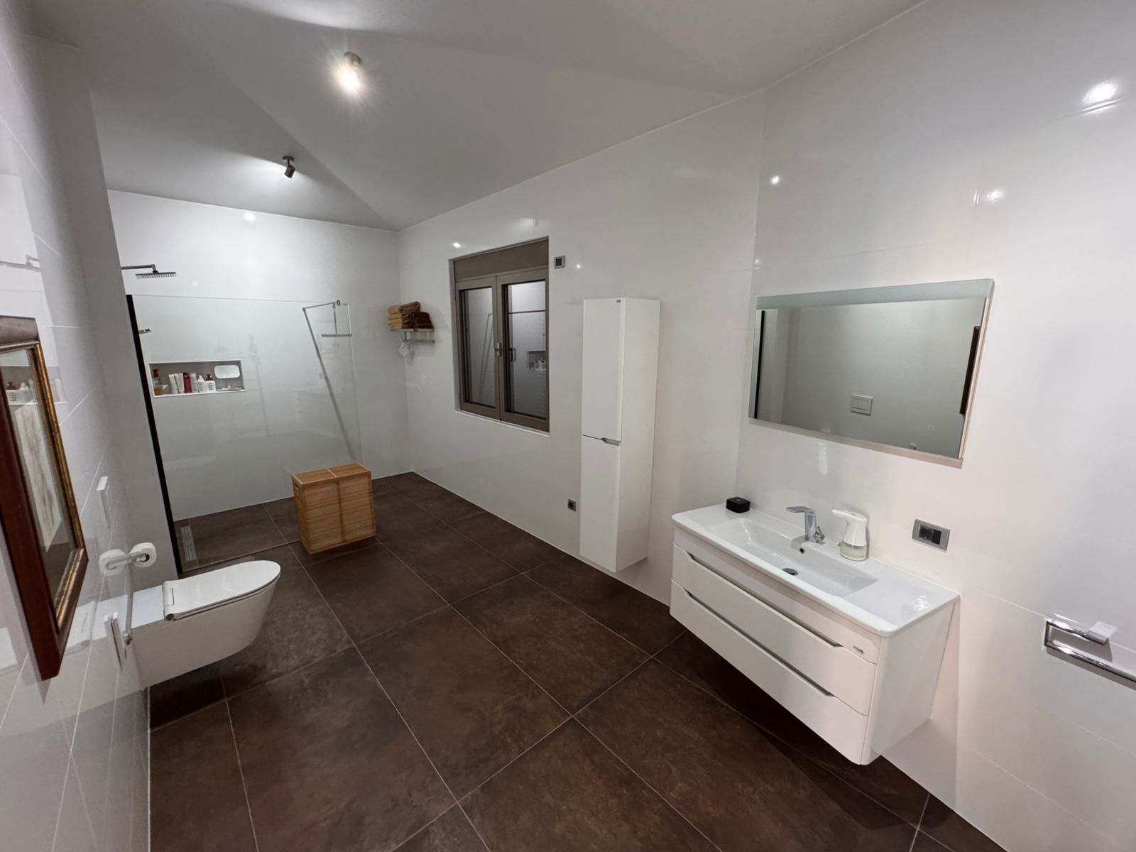 Modern Ulcinj bathroom: white walls, brown tiles, walk-in shower, mirror, vanity&mdash;prime Montenegro property at immobilien.ekosphere.me by ekosphere doo.