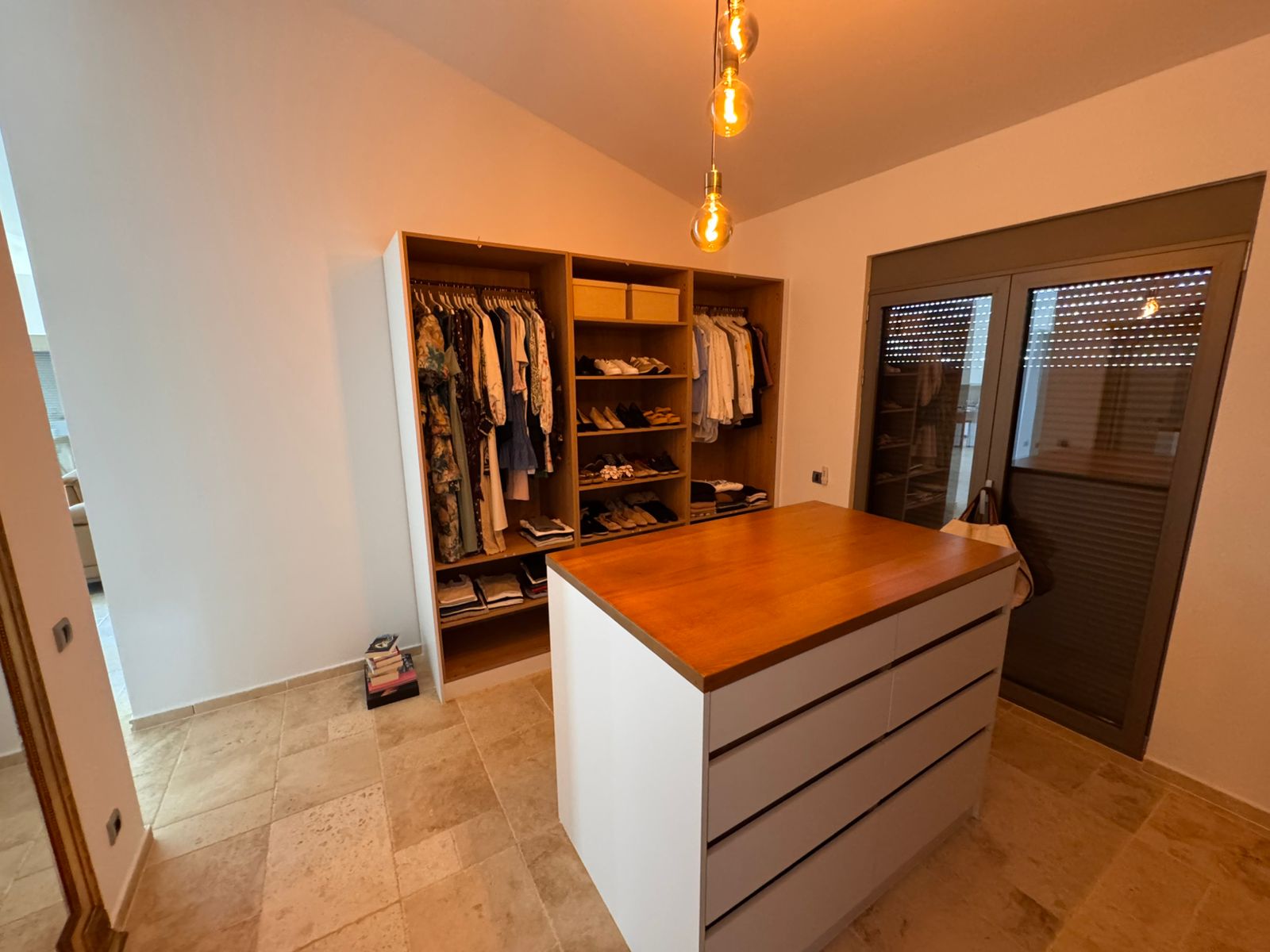 Luxury walk-in closet in Ulcinj, Montenegro: wooden island, open shelves, glass door. Exclusive on immobilien.ekosphere.me by ekosphere doo.