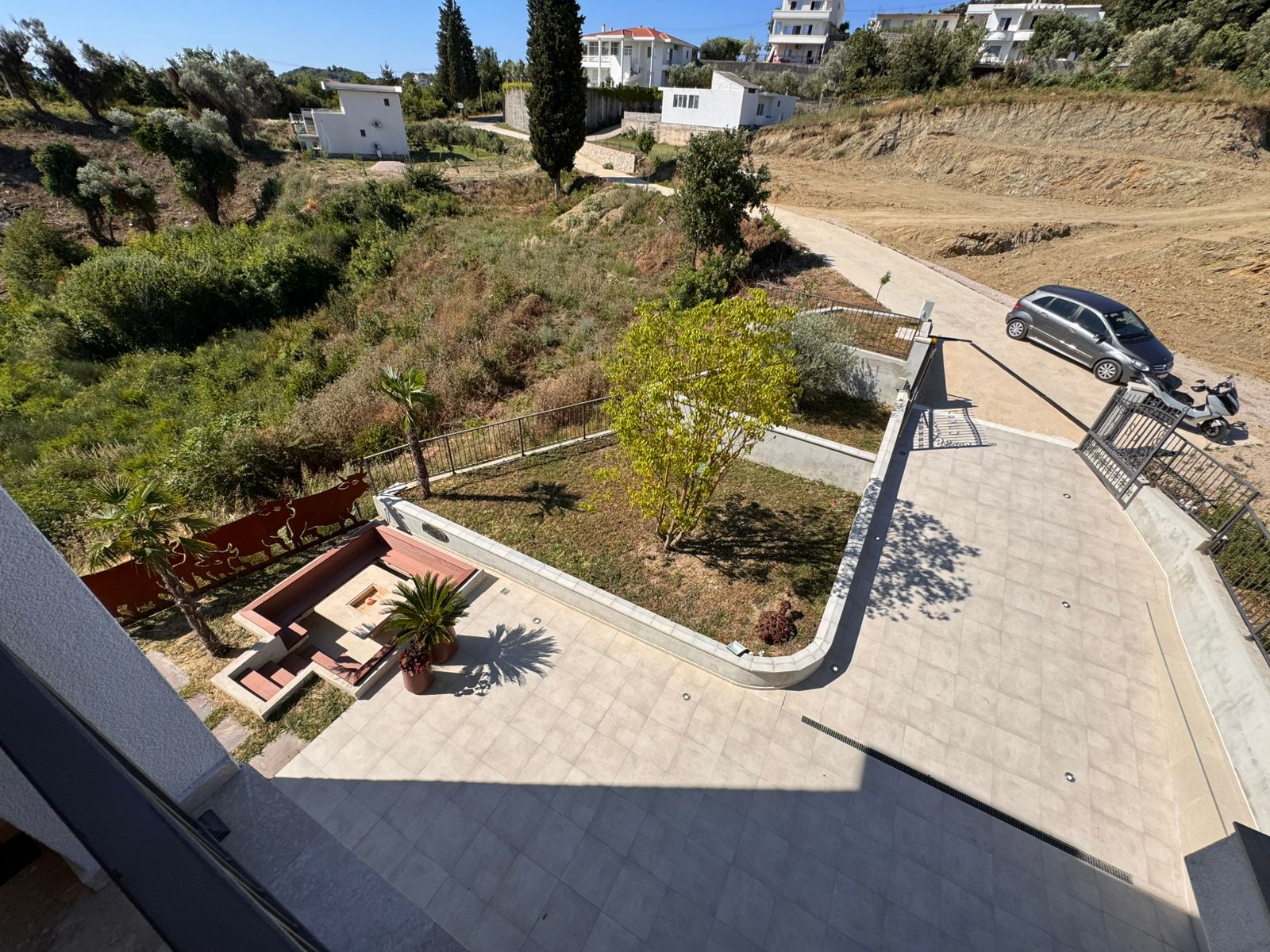 Aerial view: stylish patio, private garden, palm, and seating&mdash;prime Ulcinj property near white homes. Listed on immobilien.ekosphere.me by ekosphere doo.