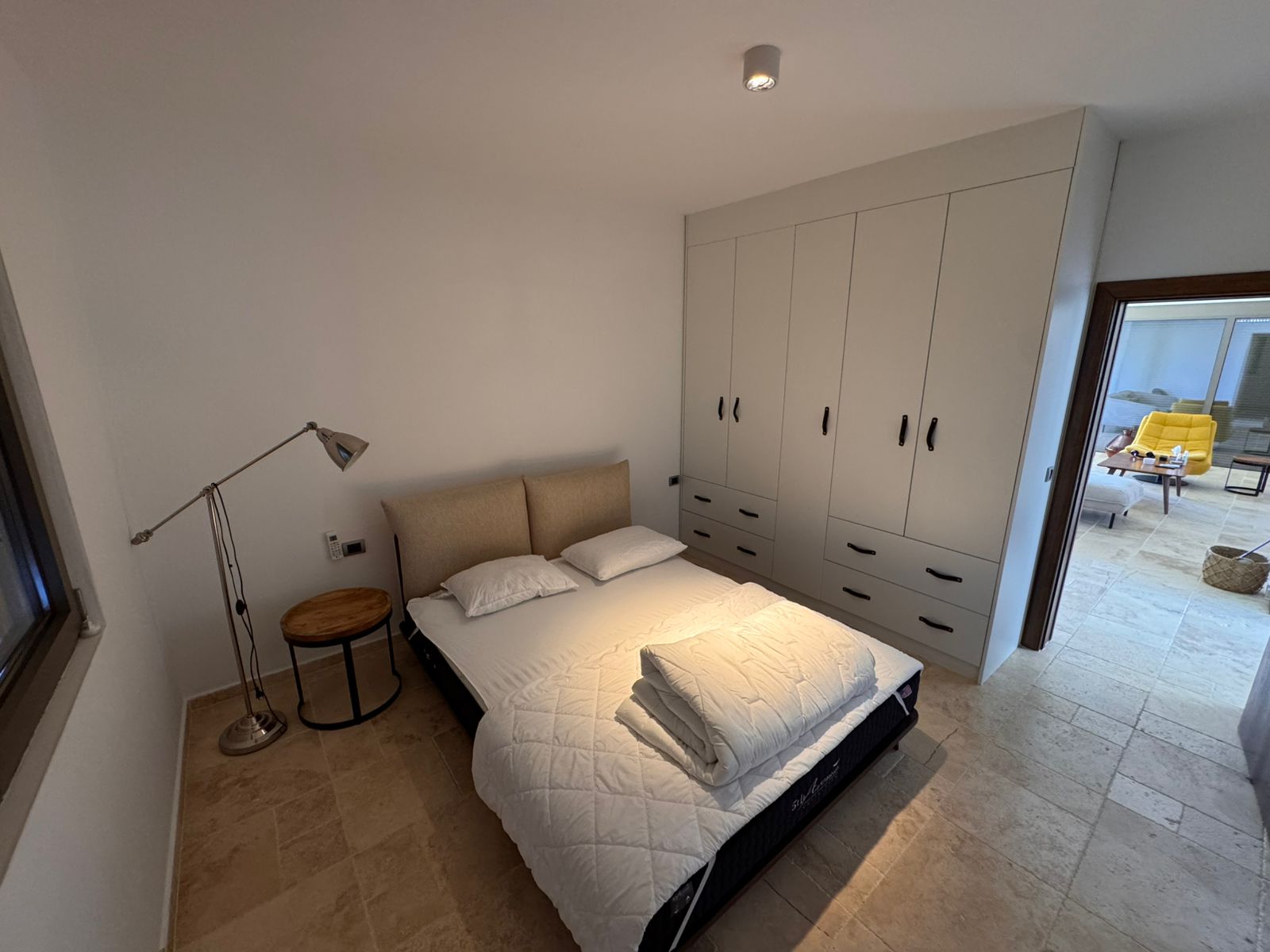 Modern Ulcinj bedroom: double bed, fresh towels, built-in wardrobe, tiled floors. Invest in Montenegro homes at immobilien.ekosphere.me.