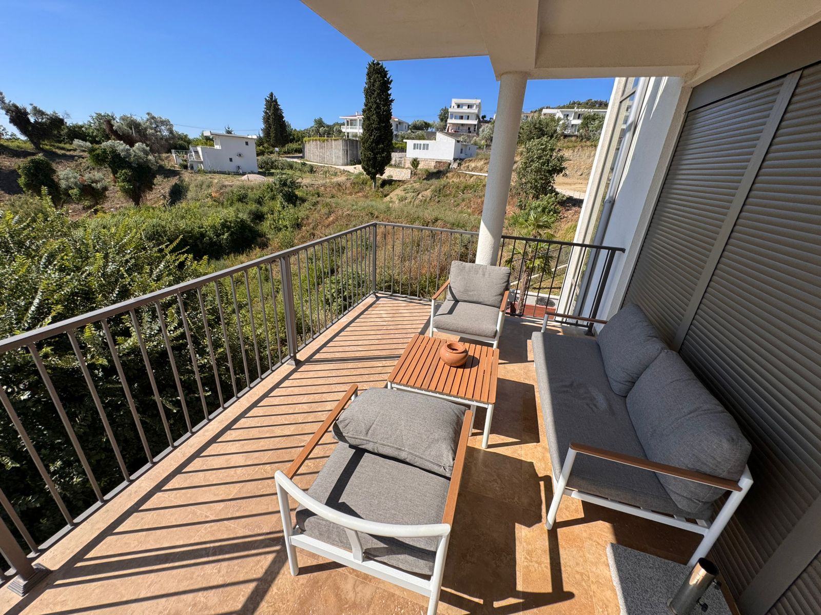 Modern balcony with stylish outdoor seating and coffee table, boasting panoramic Ulcinj views&mdash;prime Ekosphere doo investment via immobilien.ekosphere.me.