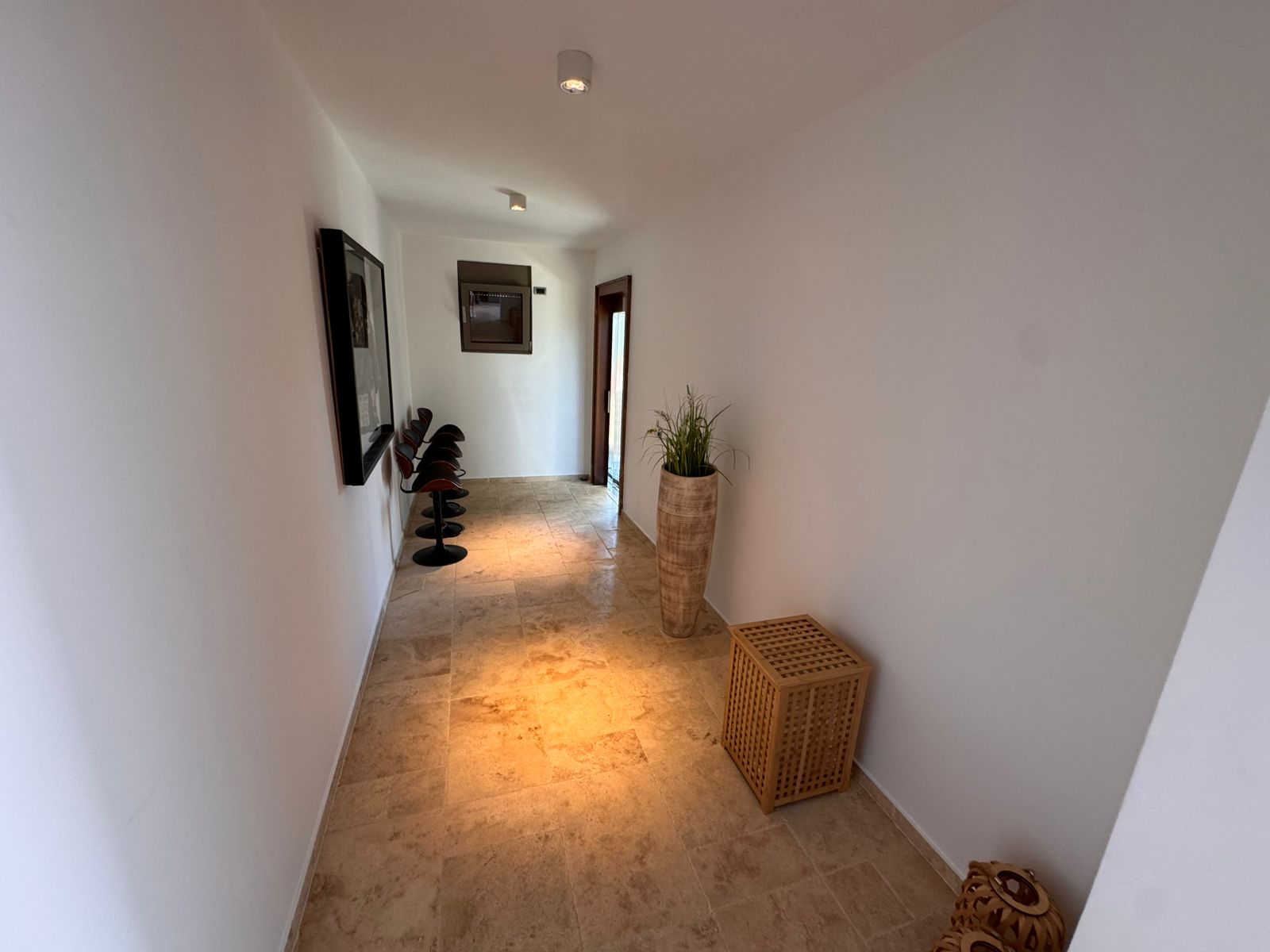 Elegant hallway in Ulcinj Montenegro real estate; beige tiles, modern lighting, chic furnishings. Invest with immobilien.ekosphere.me by ekosphere doo.