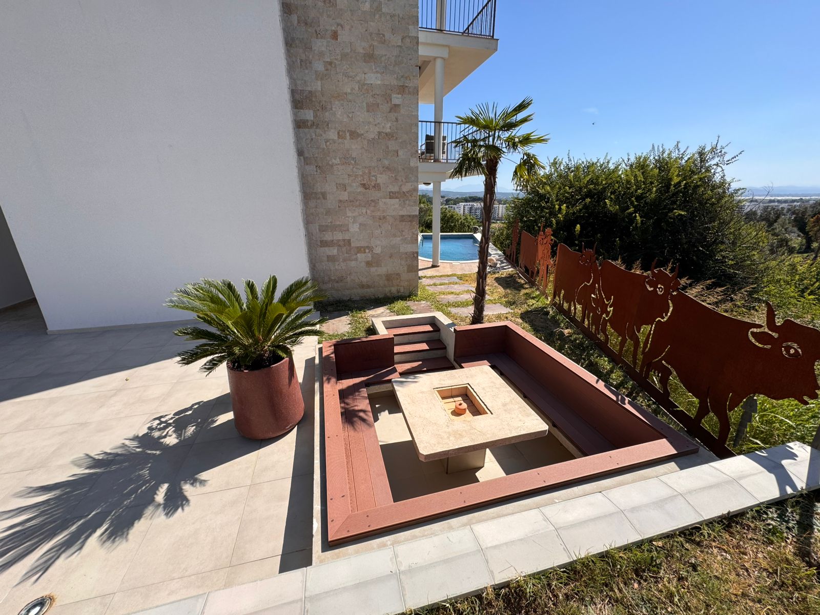 Stunning sunken fire pit with built-in seating by pool in Ulcinj Montenegro&mdash;premium real estate by Ekosphere, immobilien.ekosphere.me.
