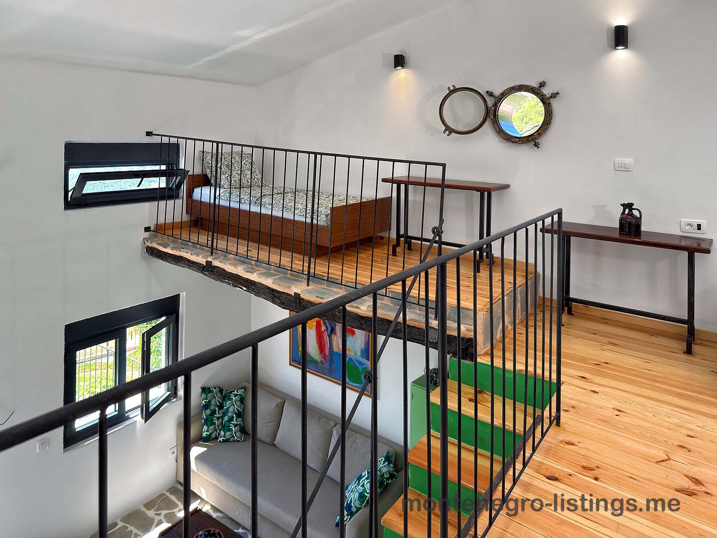 Modern loft bedroom with wood floors, metal railing, and dual mirrors, ideal Ulcinj investment at immobilien.ekosphere.me by ekosphere doo.