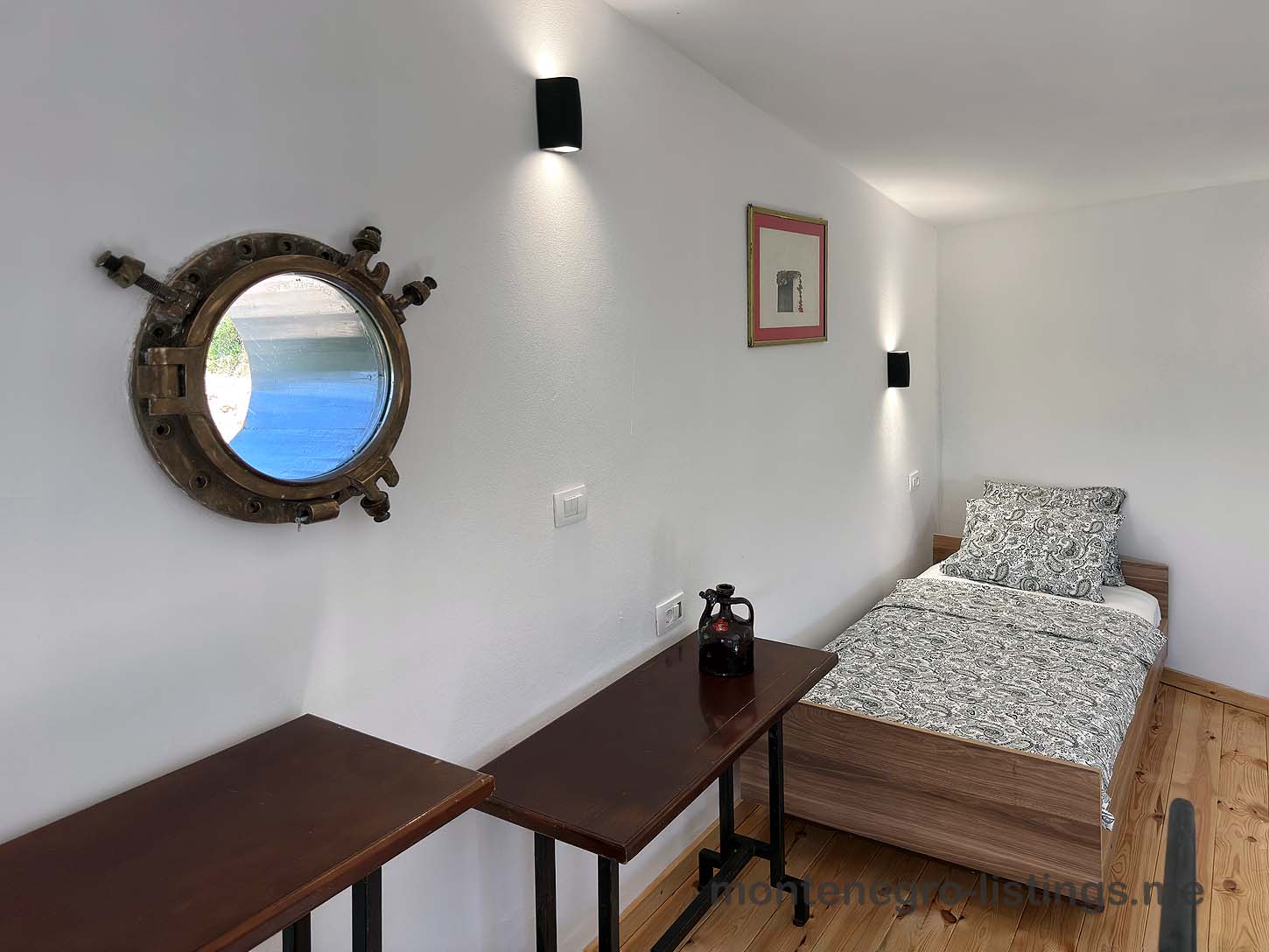 Charming Ulcinj bedroom for sale&mdash;wood floors, porthole window, stylish d&eacute;cor. Exclusive on immobilien.ekosphere.me by Ekosphere.