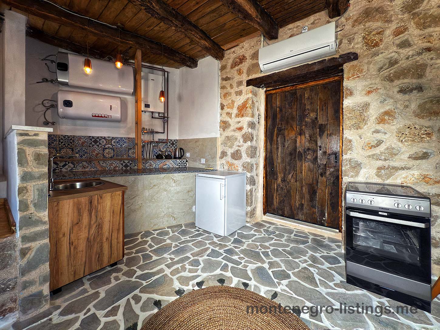 Charming rustic kitchen in Ulcinj with stone floors, wood ceiling, classic amenities&mdash;ideal Montenegro investment by Ekosphere on immobilien.ekosphere.me.