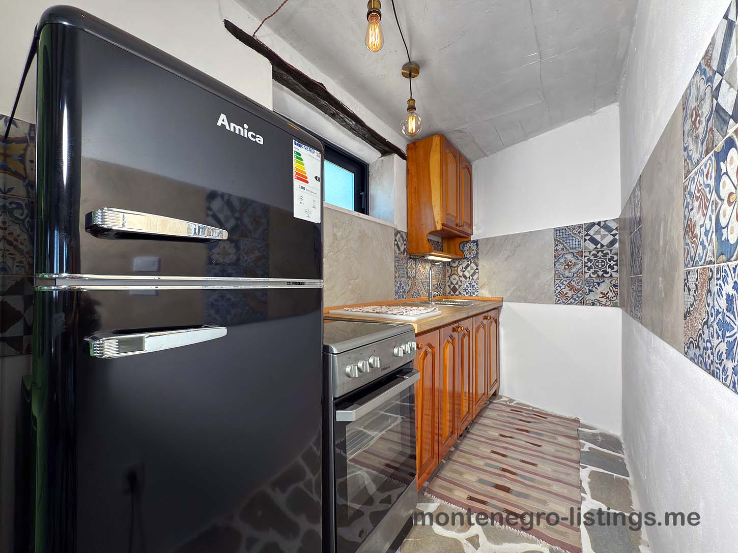 Modern Ulcinj kitchen: sleek Amica appliances, stylish tiles, wood cabinets&mdash;ideal Montenegro property. Listed on immobilien.ekosphere.me by ekosphere doo.