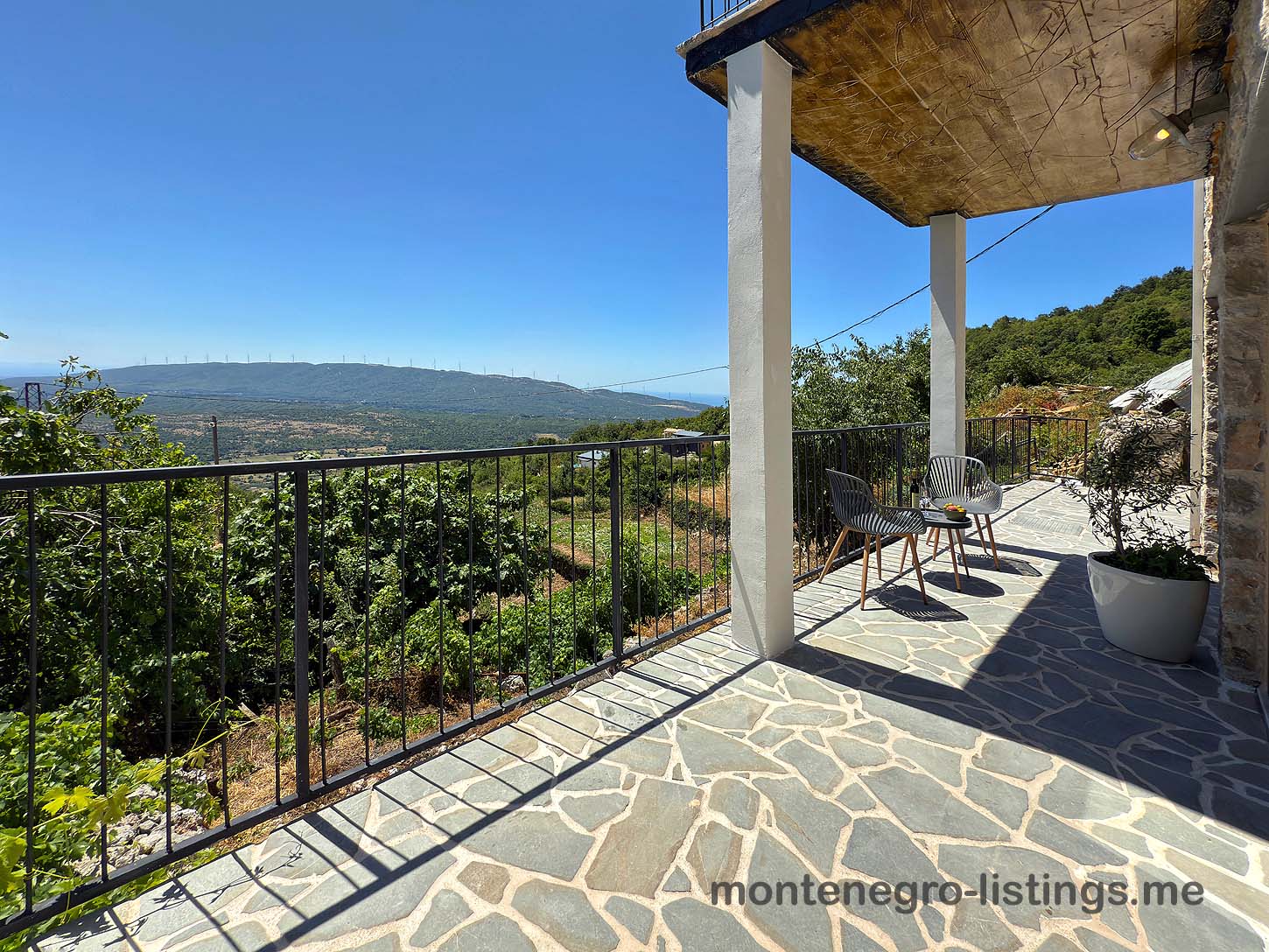 Elegant stone patio with metal railing, panoramic Ulcinj valley views&mdash;prime Montenegro real estate by ekosphere doo at immobilien.ekosphere.me.