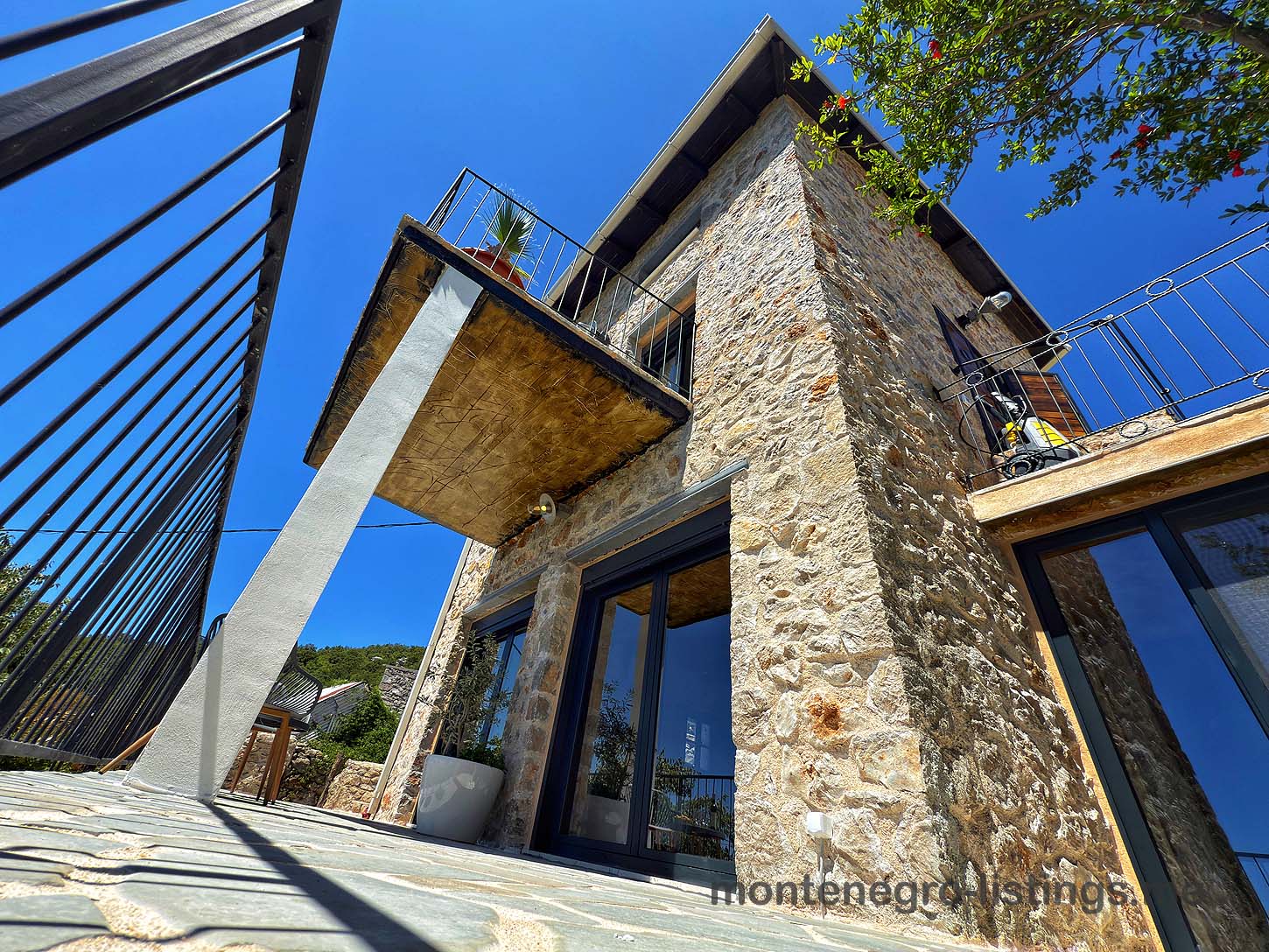 Listings for Sale - Stone villa in Ulcinj, Montenegro with large windows, metal-railed balcony; exclusive on immobilien.ekosphere.me by Ekosphere DOO.