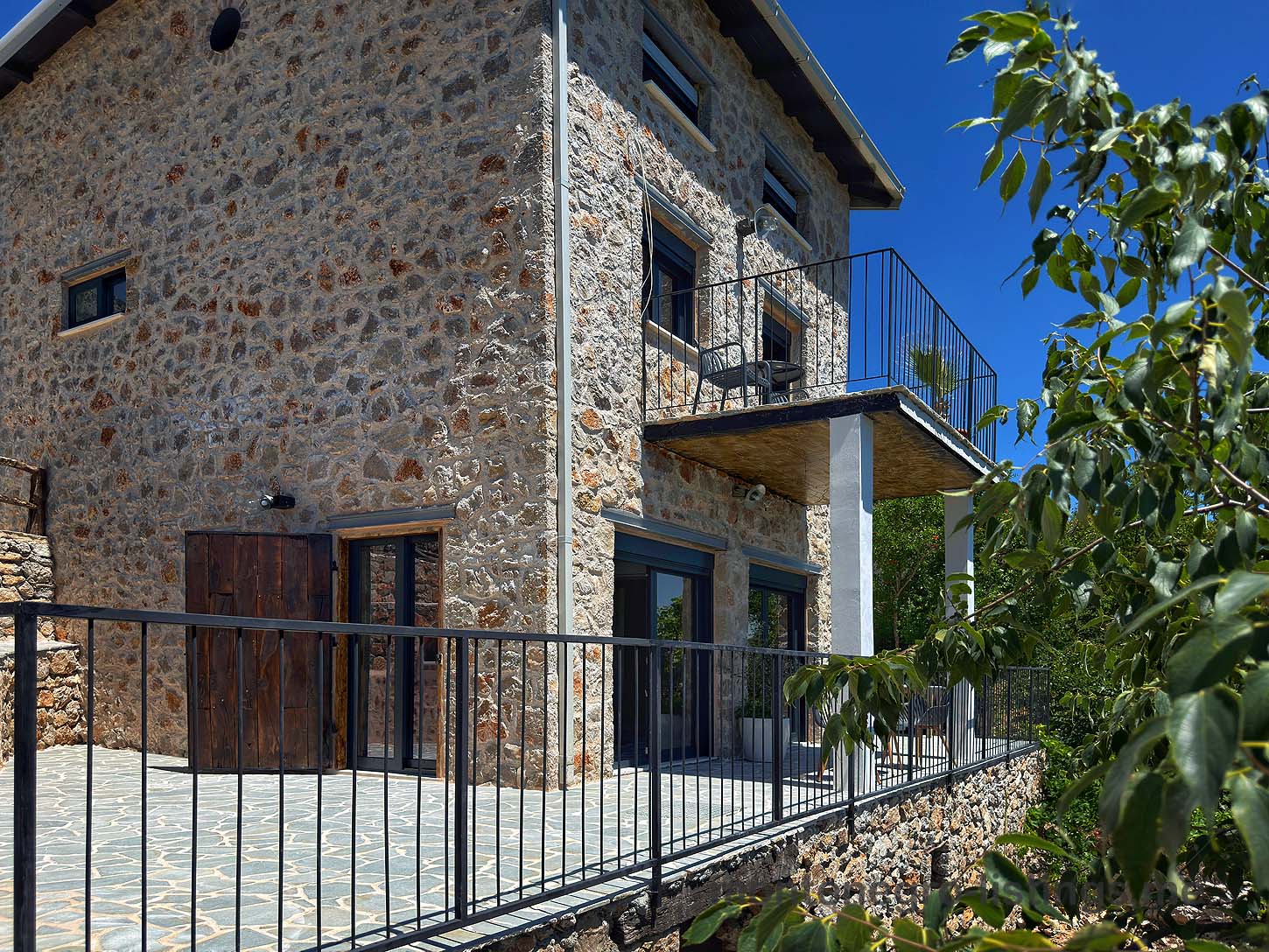 Elegant two-story stone house in Ulcinj, Montenegro&mdash;spacious balcony, glass doors, tiled patio. Exclusive on immobilien.ekosphere.me, a project by ekosphere doo.