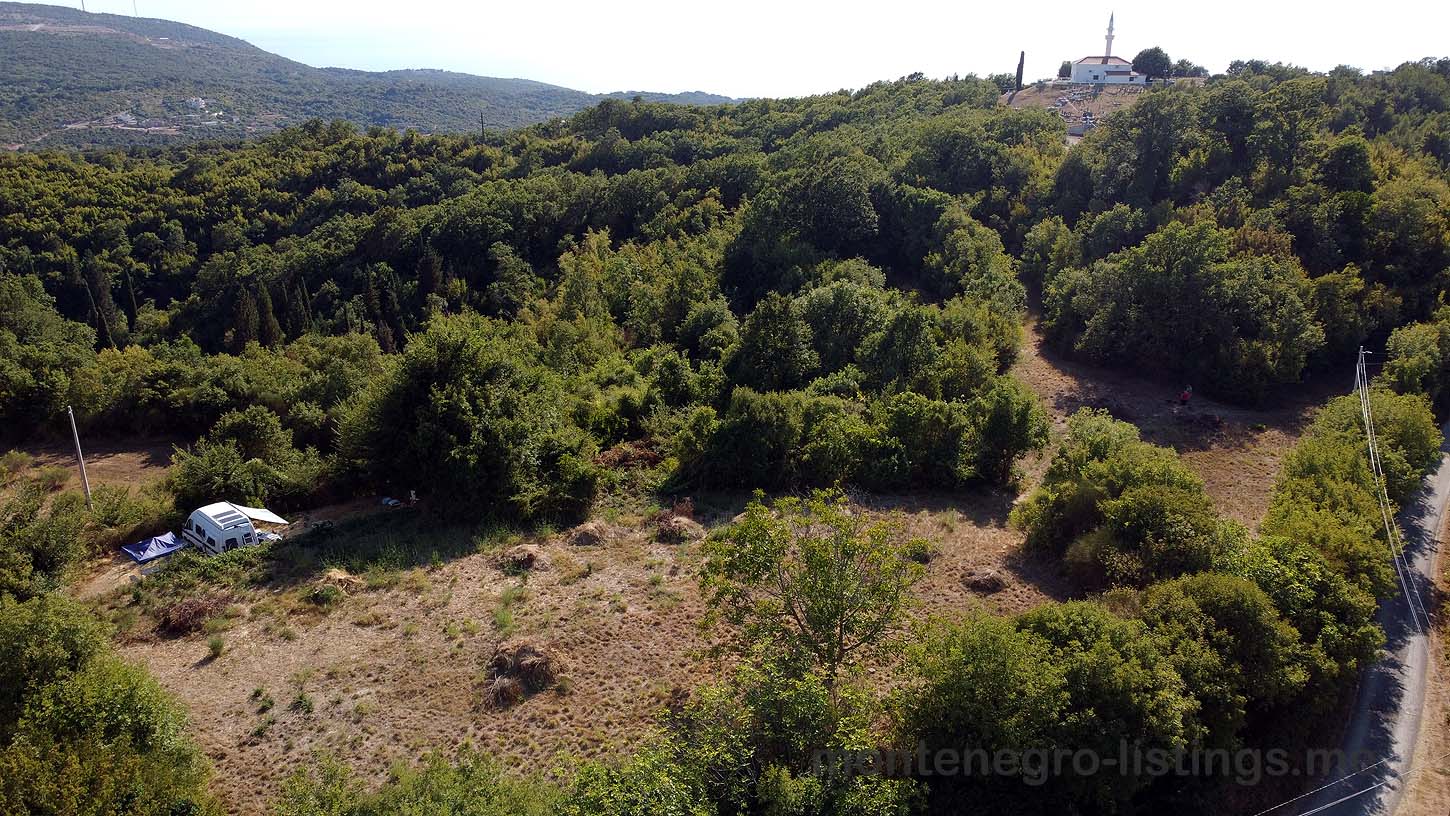 Aerial view of prime Ulcinj real estate&mdash;forest hills, road access, and ekosphere doo site. Invest with immobilien.ekosphere.me today!.