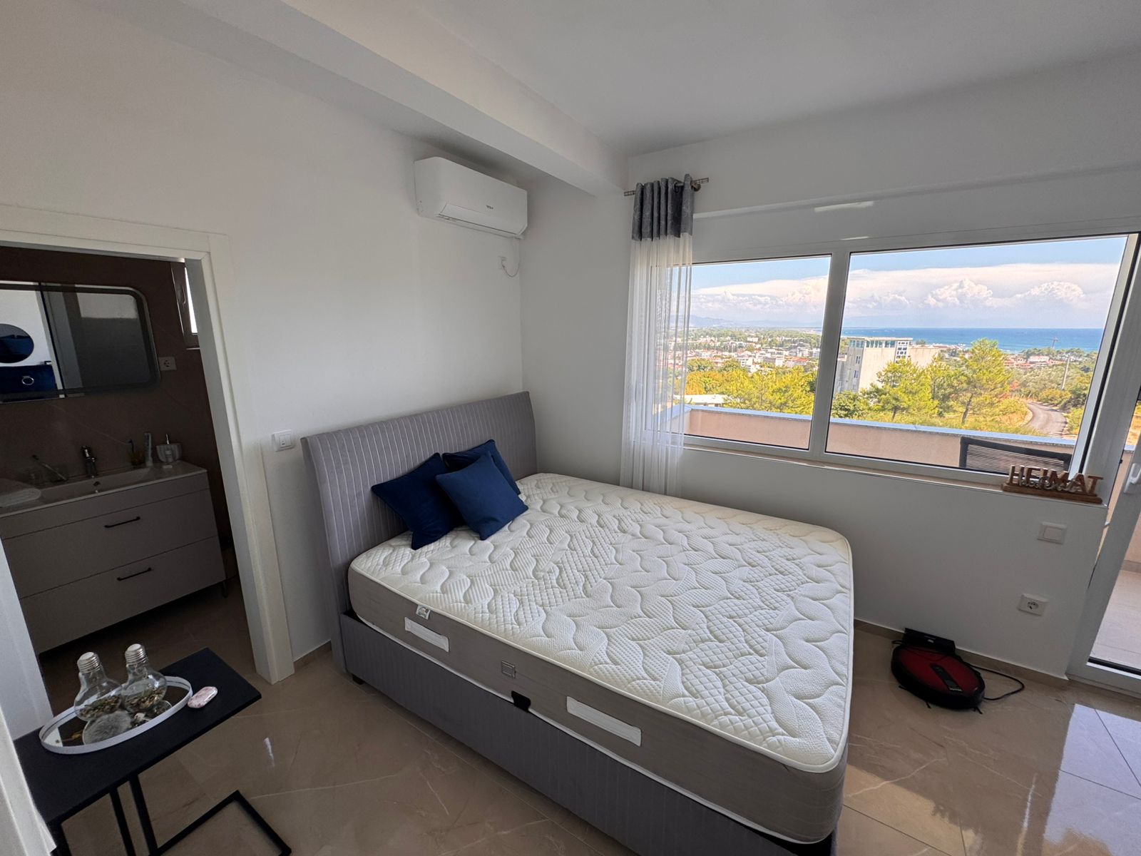 Bright Ulcinj bedroom with large window, sea and city views, ensuite bath. Premium investment at immobilien.ekosphere.me by ekosphere doo.