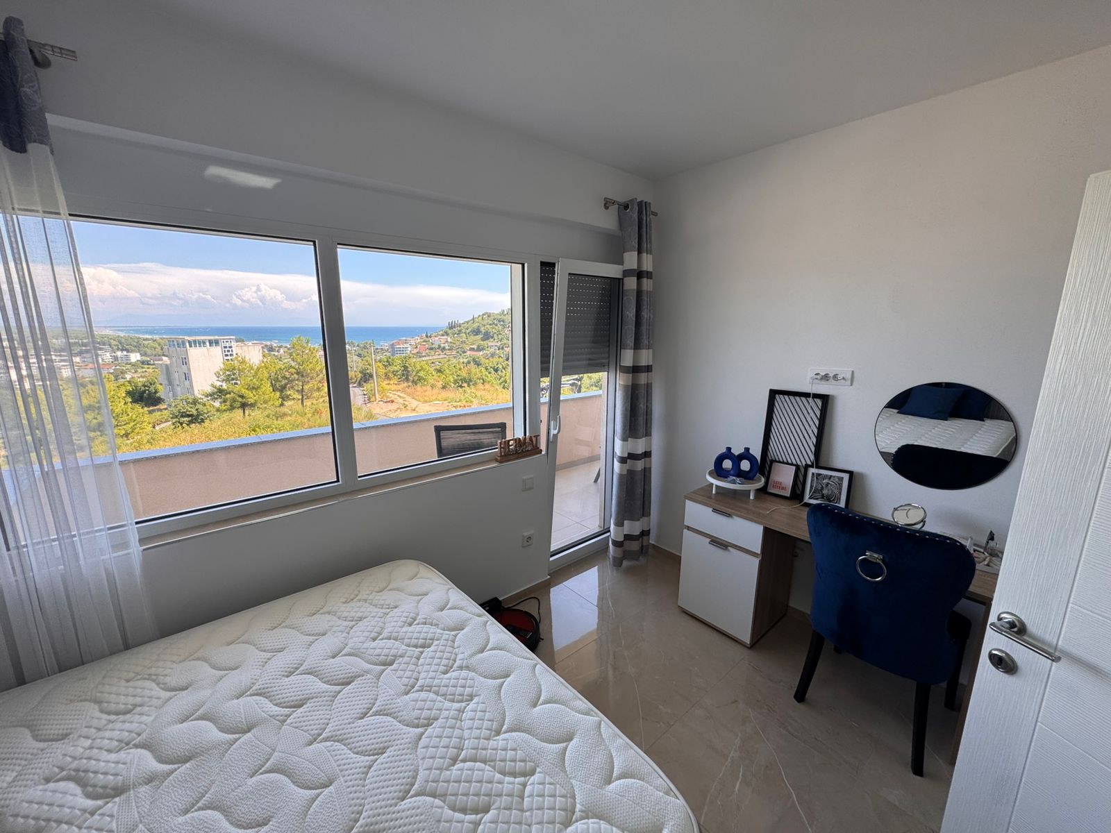 Modern Ulcinj bedroom with sea view, balcony, stylish desk and airy Ekosphere design&mdash;exclusive on immobilien.ekosphere.me property portal.