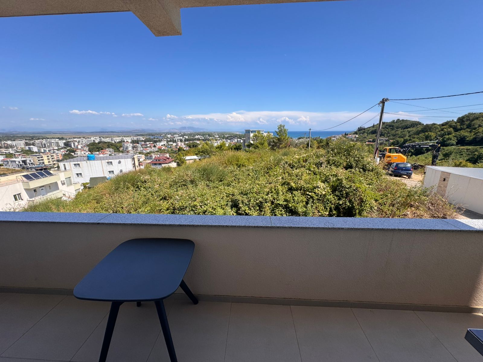 Stylish Ulcinj balcony with black table, green views, blue skies, cityscape&mdash;prime real estate via immobilien.ekosphere.me by ekosphere doo.
