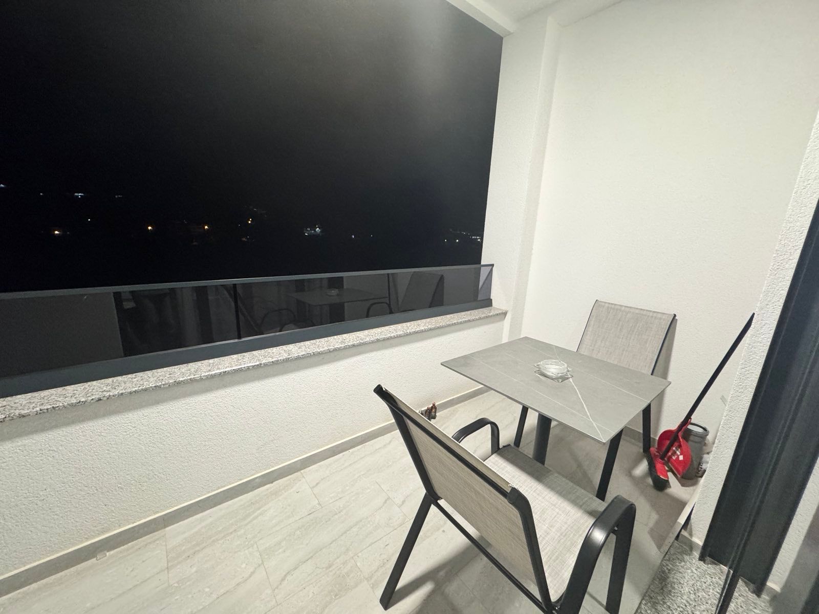 Elegant, clean Ulcinj balcony with table, chairs, and night views&mdash;ideal Montenegro investment. Exclusive on immobilien.ekosphere.me.