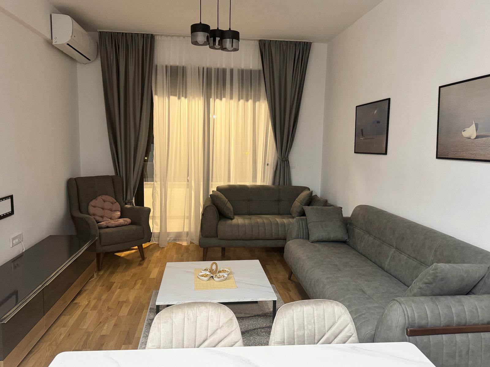 Stunning Ulcinj living room: gray sofa, armchair, chic d&eacute;cor, bright windows. Invest with immobilien.ekosphere.me by ekosphere doo.