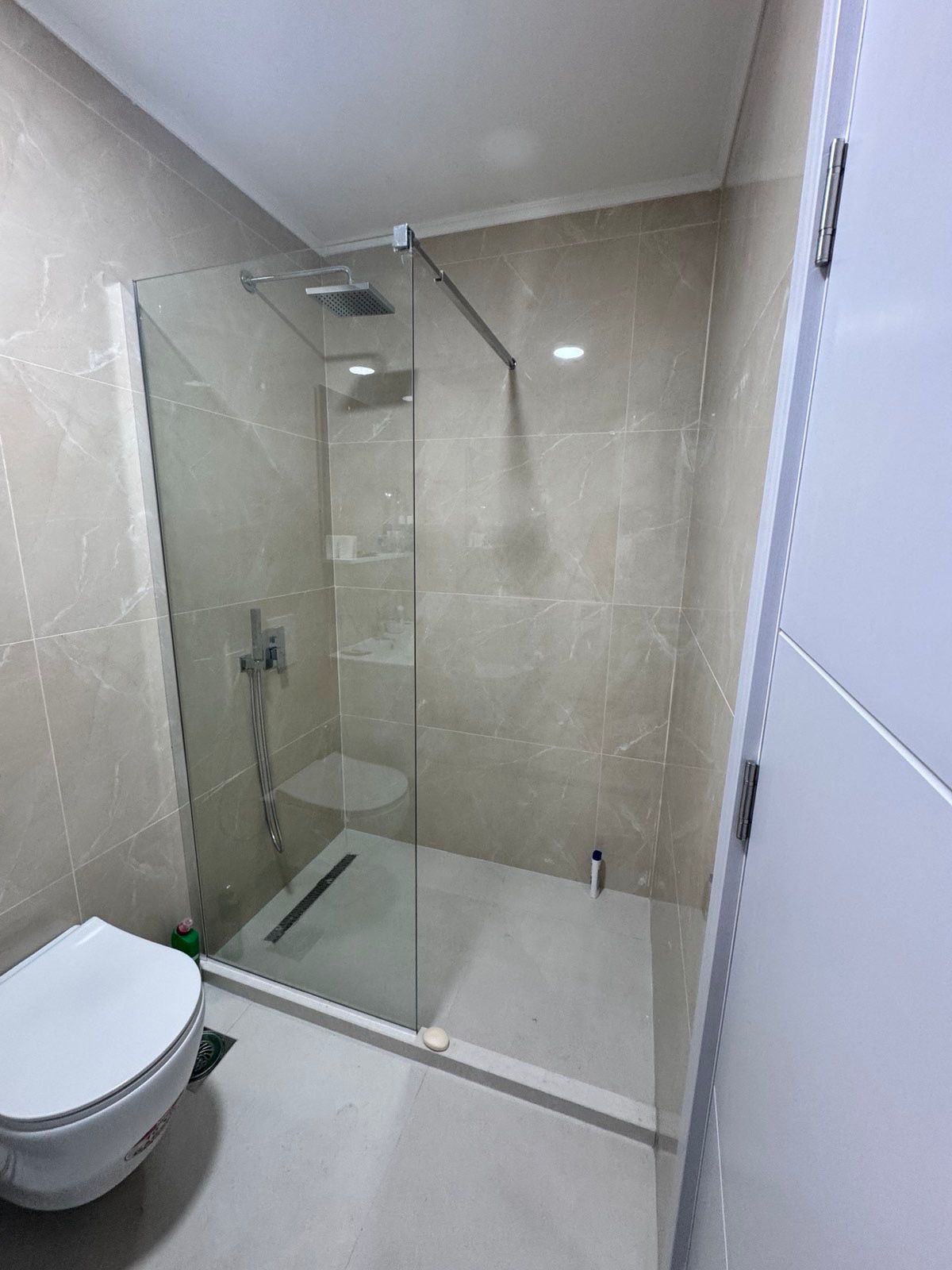 Elegant modern bathroom in Ulcinj, Montenegro with beige tiles, walk-in shower, premium fixtures. Exclusively at immobilien.ekosphere.me.