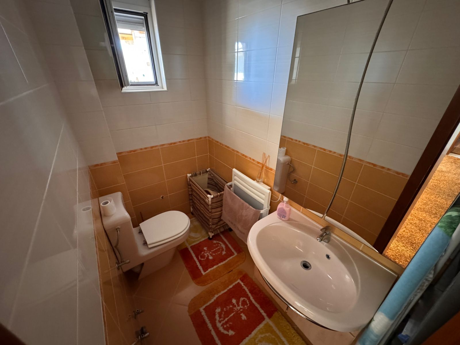 Stylish Ulcinj bathroom: modern white sink, mirror, bright window, quality tiling. Exclusive at immobilien.ekosphere.me by ekosphere doo.