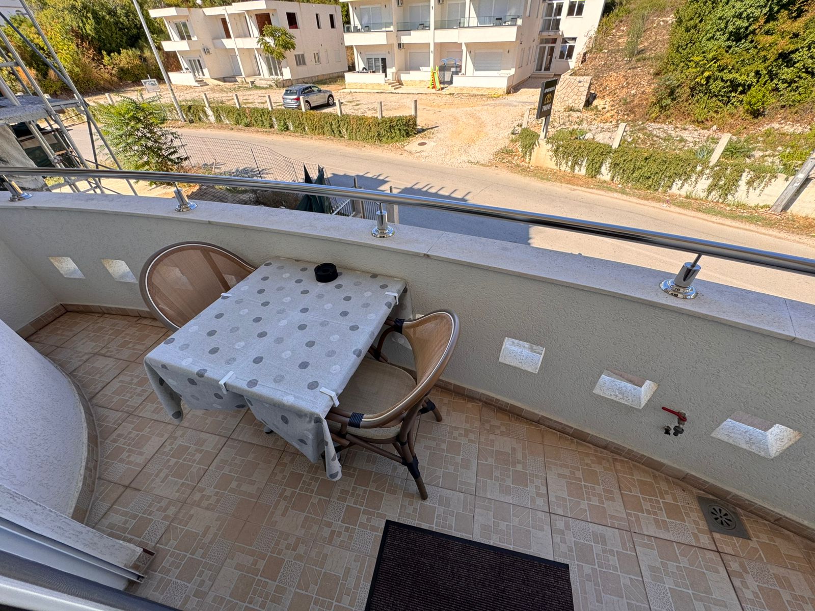 Charming Ulcinj balcony with modern tiles, metal railing, and outdoor seating. Invest in Montenegro real estate at immobilien.ekosphere.me &ndash; a project of ekosphere doo.