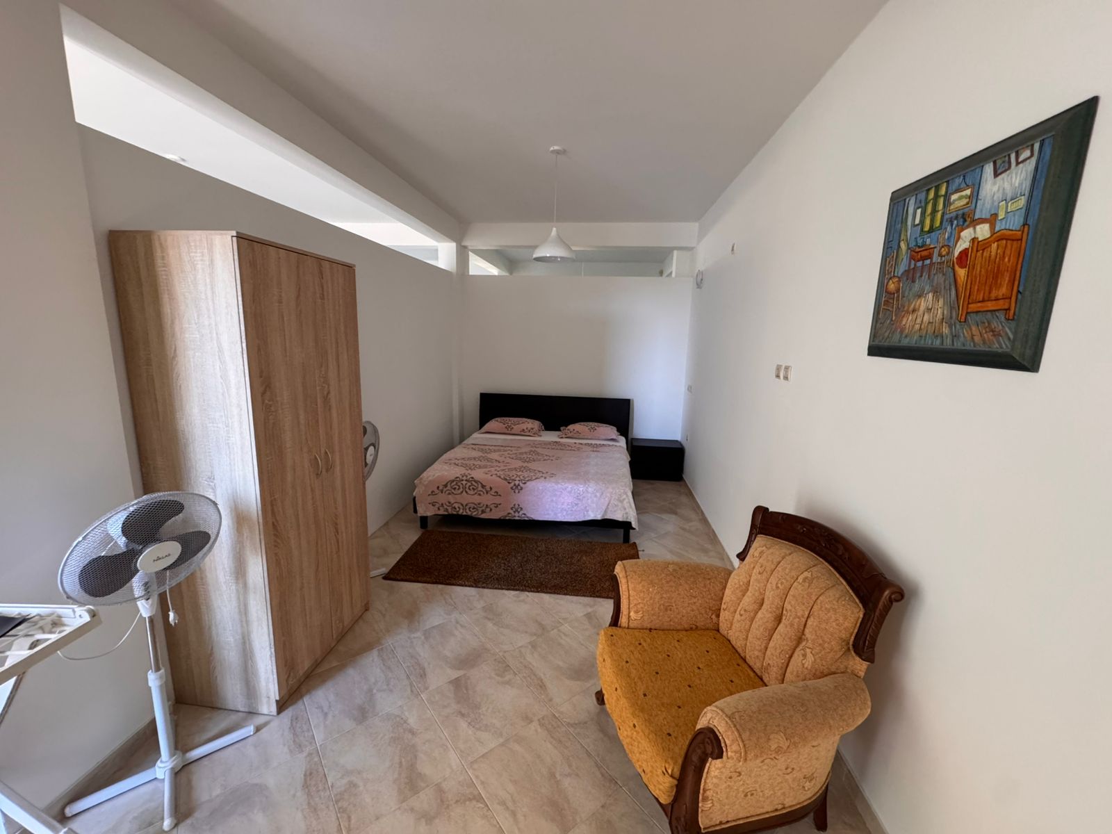 Modern Ulcinj bedroom with double bed, pink bedding, wardrobe, armchair. Ideal investment via immobilien.ekosphere.me by ekosphere doo.