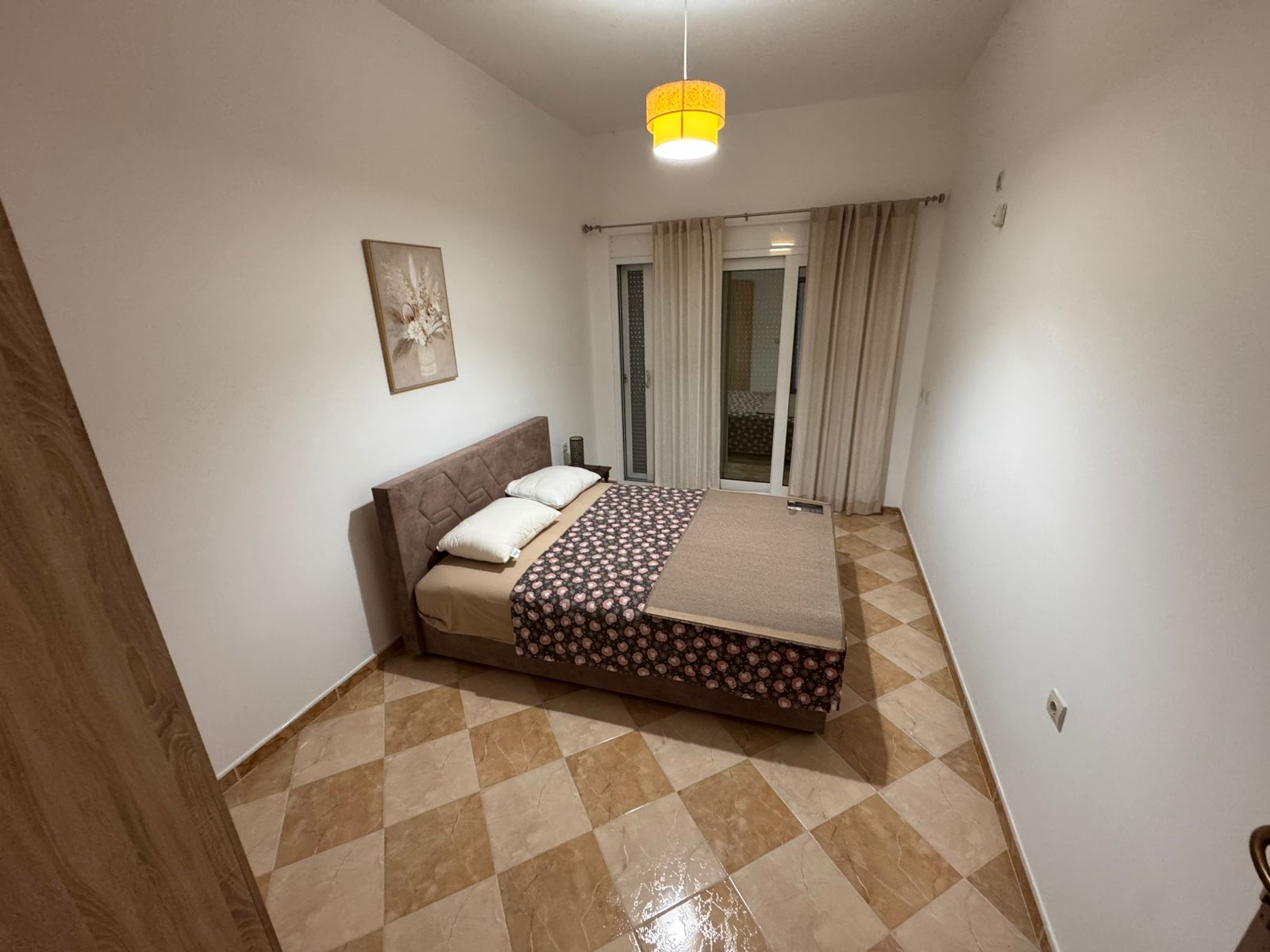 Bright Ulcinj bedroom with double bed, stylish d&eacute;cor, large glass doors, tiled floor&mdash;ideal Montenegro investment via immobilien.ekosphere.me.