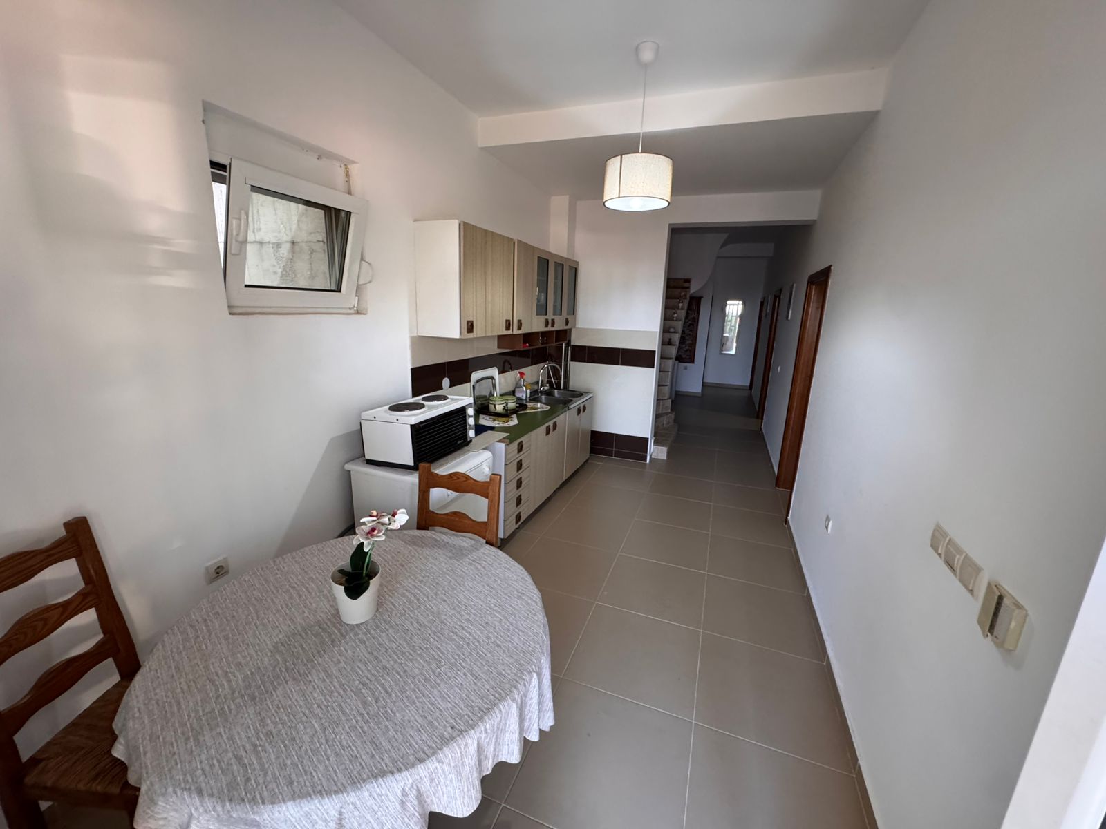 Charming Ulcinj kitchen with a modern layout, quality cabinets, dining nook, and bright hallway &mdash; exclusive at immobilien.ekosphere.me by ekosphere doo.