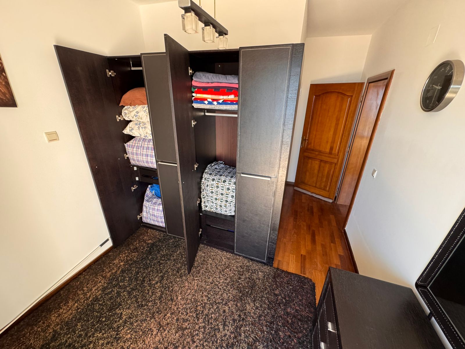 Modern dark wood wardrobe with organized storage in Ulcinj property; stylish flooring, premium interiors&mdash;exclusive at immobilien.ekosphere.me by Ekosphere DOO.