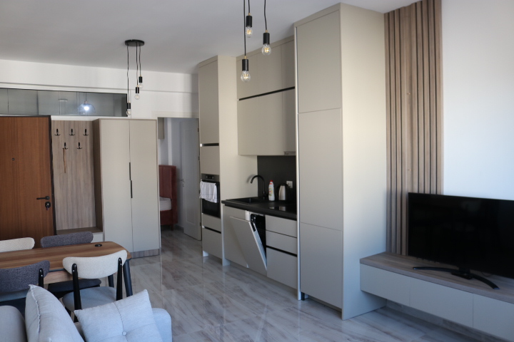 Modernes Appartement in Ulcinj: helle Schr&auml;nke, Einbauten, Designer-Beleuchtung, Wand-TV, Esstisch, graues Sofa. Exklusiv bei immobilien.ekosphere.me von ekosphere doo. 