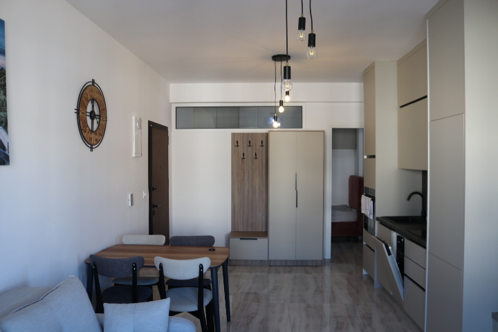Stylish Ulcinj studio apartment with dining area, modern kitchen, cozy sofa, alcove bed. Invest in Montenegro at immobilien.ekosphere.me by ekosphere doo.