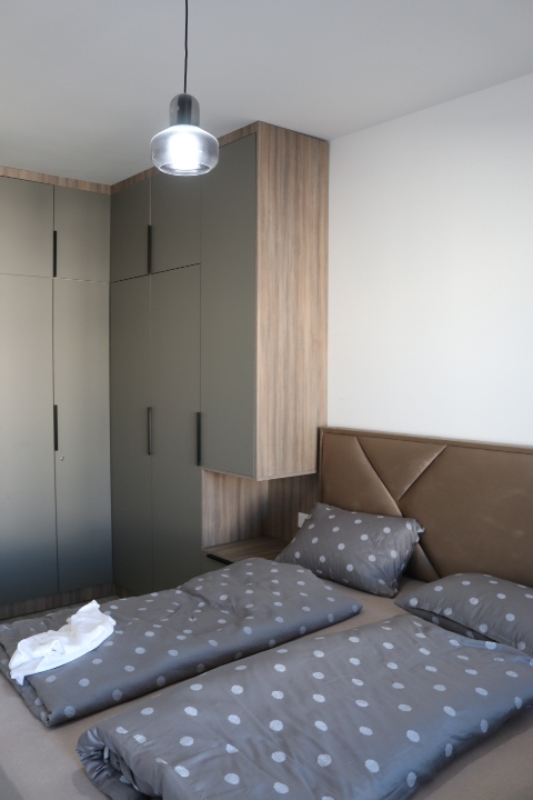 Elegant modern bedroom in Ulcinj with stylish double bed, custom wood cabinetry, and premium finishes&mdash;exclusive from immobilien.ekosphere.me.