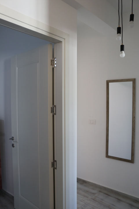 Step into this modern Ulcinj apartment: sleek gray wood floors, elegant lighting, and quality finishes. See more on immobilien.ekosphere.me by ekosphere doo.