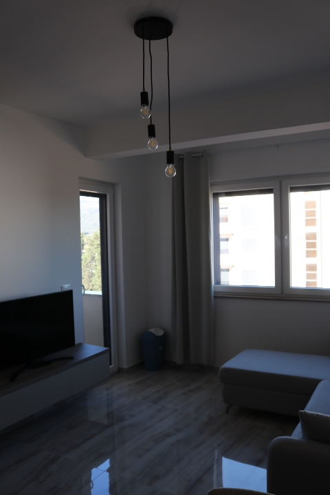 Stylish, modern Ulcinj living room with large windows, gray sectional, and chic lighting&mdash;top property at immobilien.ekosphere.me by ekosphere doo.