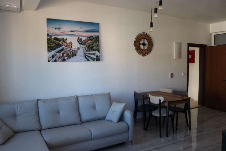 Bright, modern living room in Ulcinj with a light gray sofa, dining area, stylish decor&mdash;exclusive at immobilien.ekosphere.me by ekosphere doo.