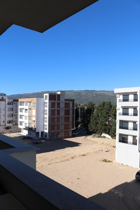Prime Ulcinj property: modern apartments, open development land, panoramic hill views with wind turbines. Powered by ekosphere doo.