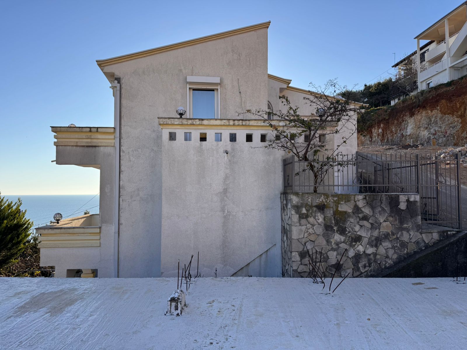 Modern two-story white home with a flat roof, sea views, driveway, and stone wall&mdash;prime Ulcinj investment on immobilien.ekosphere.me.