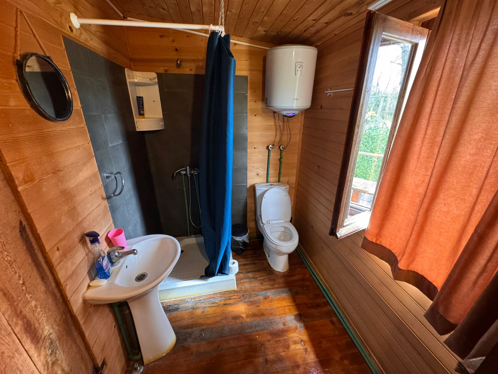 Modern wooden bathroom in Ulcinj with sunlit window, premium shower, quality fixtures. Ideal Montenegro real estate from ekosphere doo.