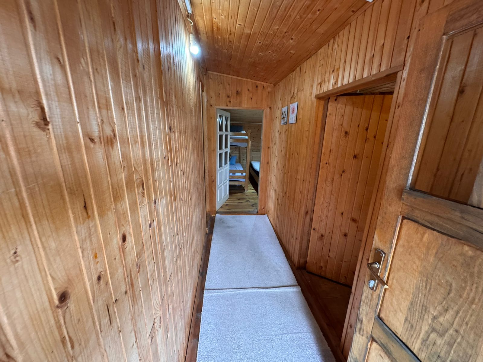 Elegant wooden hallway with premium finishes, white carpets, and cozy bunk beds&mdash;exclusive Ulcinj listing at immobilien.ekosphere.me.