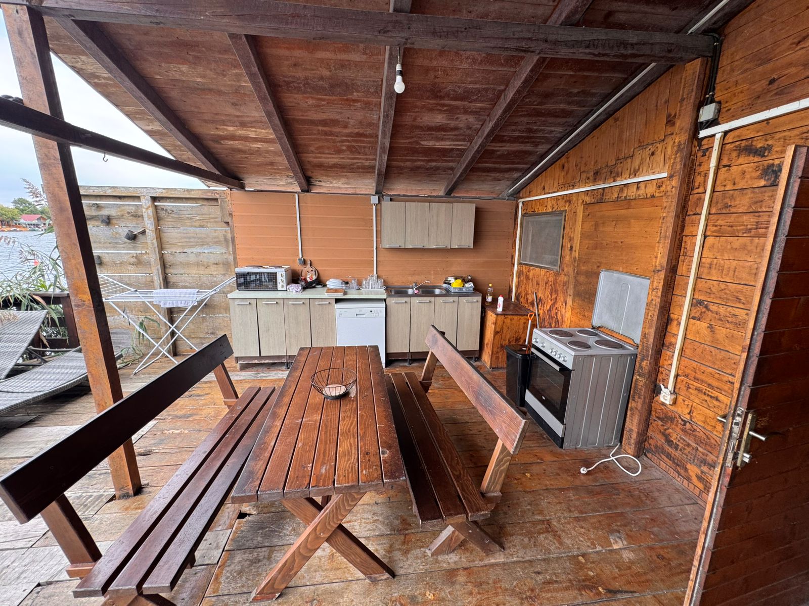 Charming rustic outdoor kitchen in Ulcinj with wood floors, dining set, appliances&mdash;ideal Montenegro investment. On immobilien.ekosphere.me.