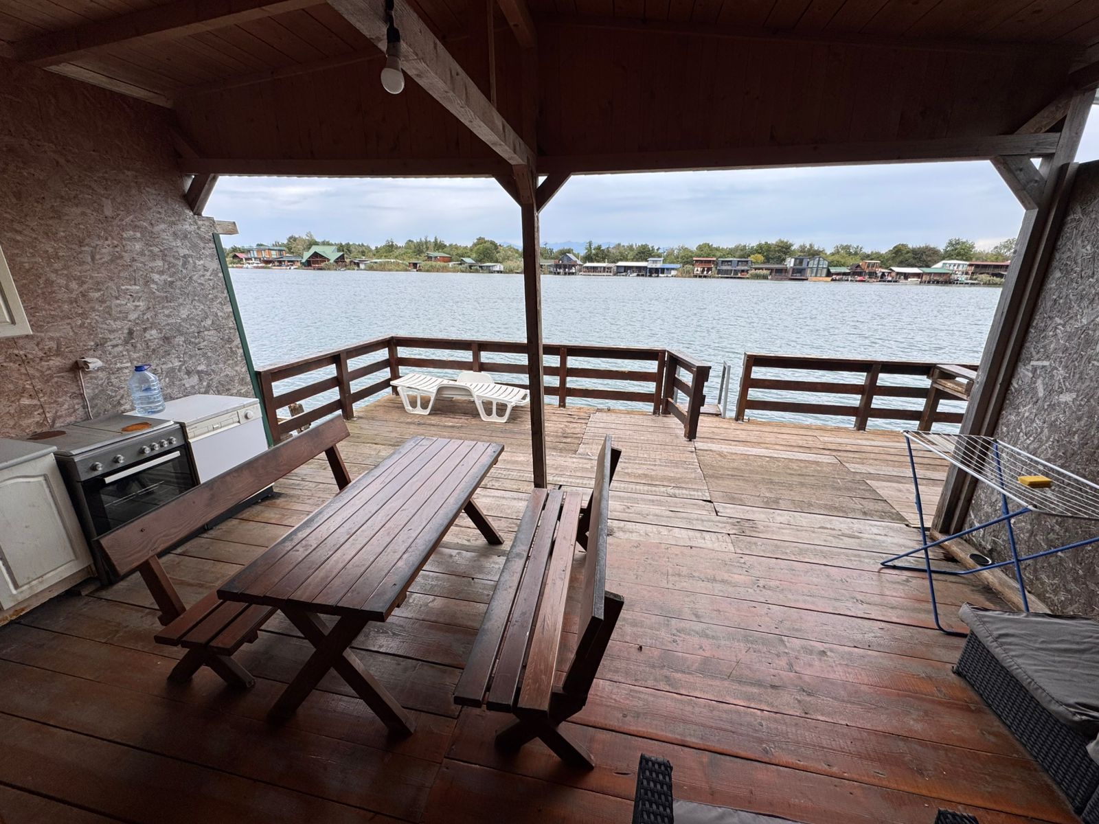 Stunning covered wooden patio with kitchen, sun loungers, and panoramic water views&mdash;prime Ulcinj real estate by ekosphere doo.