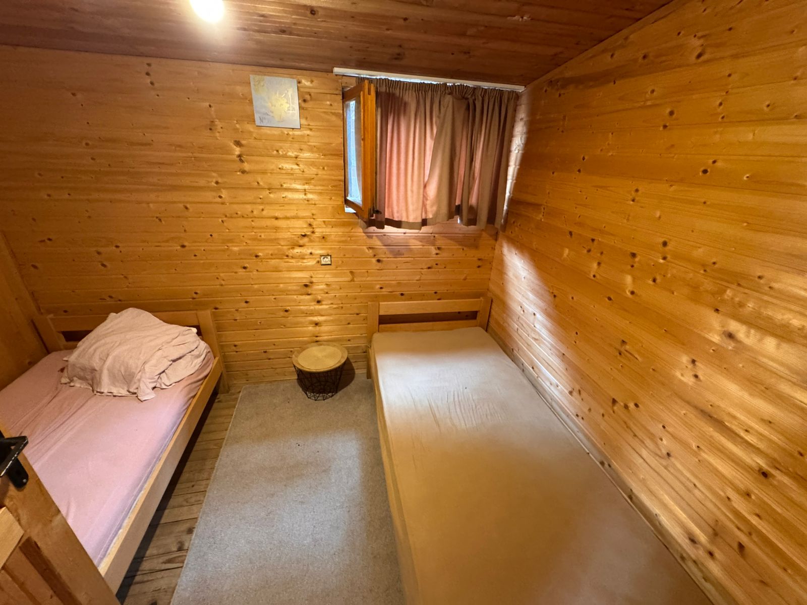 Charming Ulcinj investment: cozy twin room with wood finishes, designer beds, window, and modern lighting. Eksosphere doo listing.
