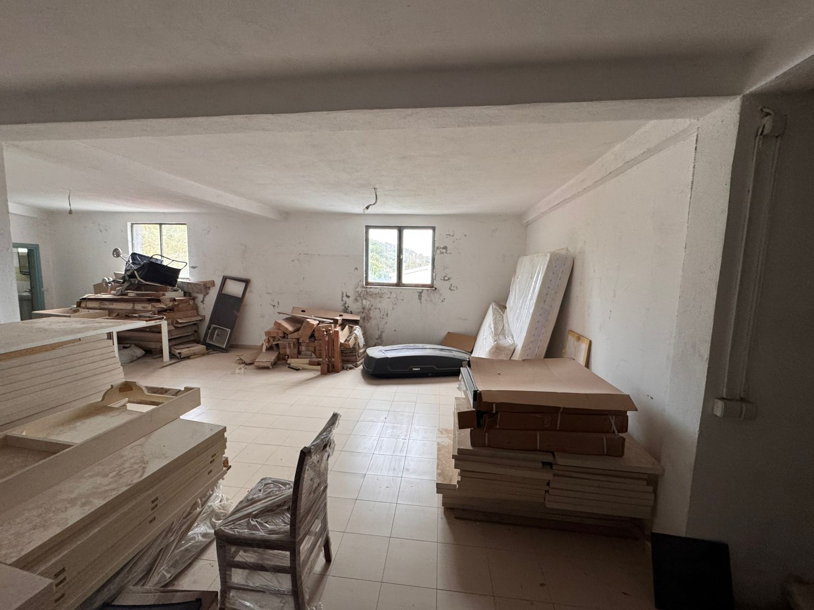 Bright room with white walls, tiled floors, large windows, renovation potential&mdash;ideal Ulcinj investment on immobilien.ekosphere.me by ekosphere doo.