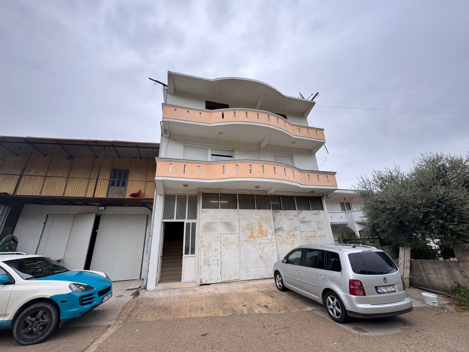 Stunning three-story peach & white building with large balconies in Ulcinj. Prime investment at immobilien.ekosphere.me by ekosphere doo.