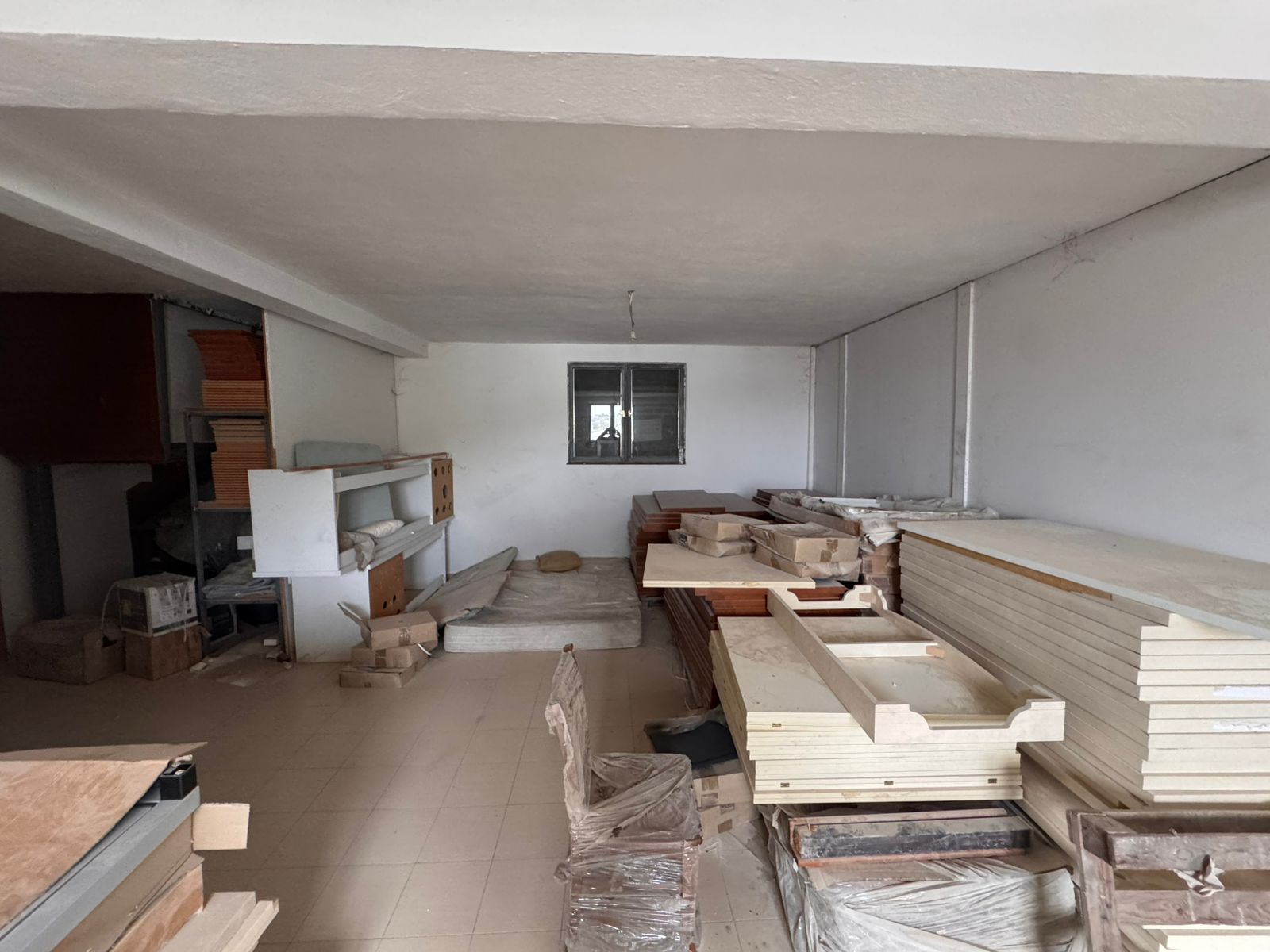 Spacious tiled storage room in Ulcinj, ideal for investment. Secure window, shelves, and ample space. See more at immobilien.ekosphere.me by ekosphere doo.