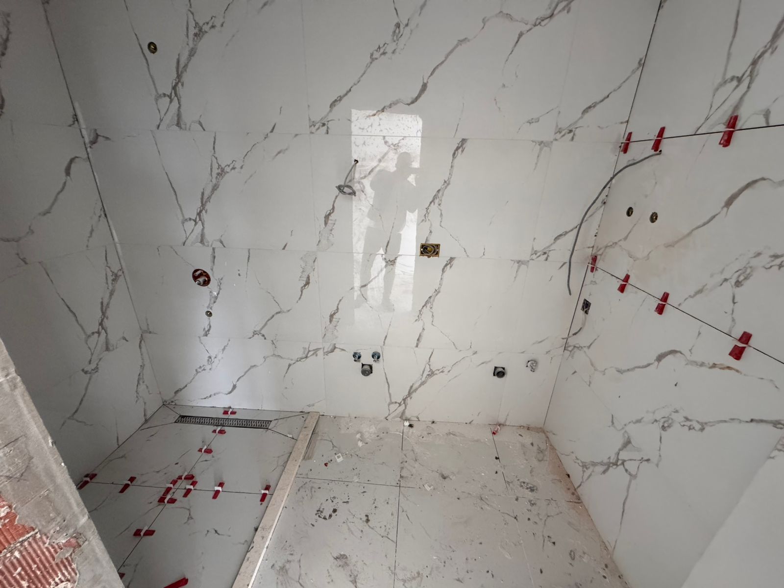 Under-construction bathroom in Ulcinj with elegant marble-effect tiles, ideal investment. Listed on immobilien.ekosphere.me by Ekosphere doo.