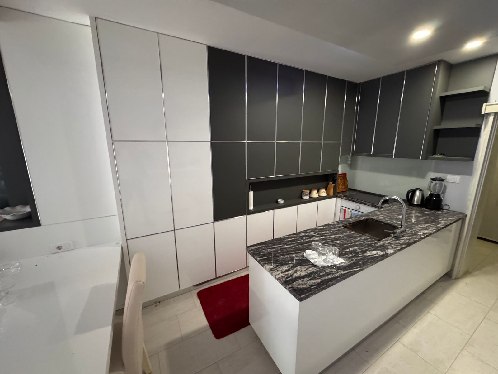 Stunning modern kitchen in Ulcinj, Montenegro&mdash;white & gray cabinetry, marbled island, premium appliances. Invest via immobilien.ekosphere.me.