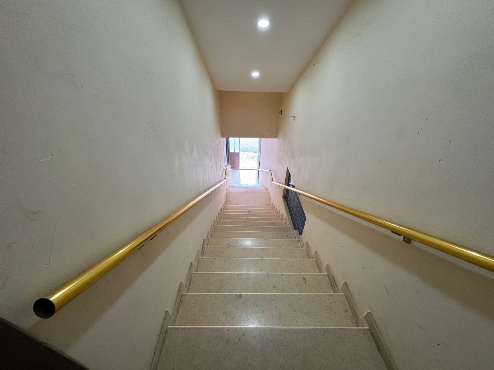 Elegant staircase with beige steps, modern yellow handrails, and bright cream walls&mdash;ideal Ulcinj home investment by immobilien.ekosphere.me.