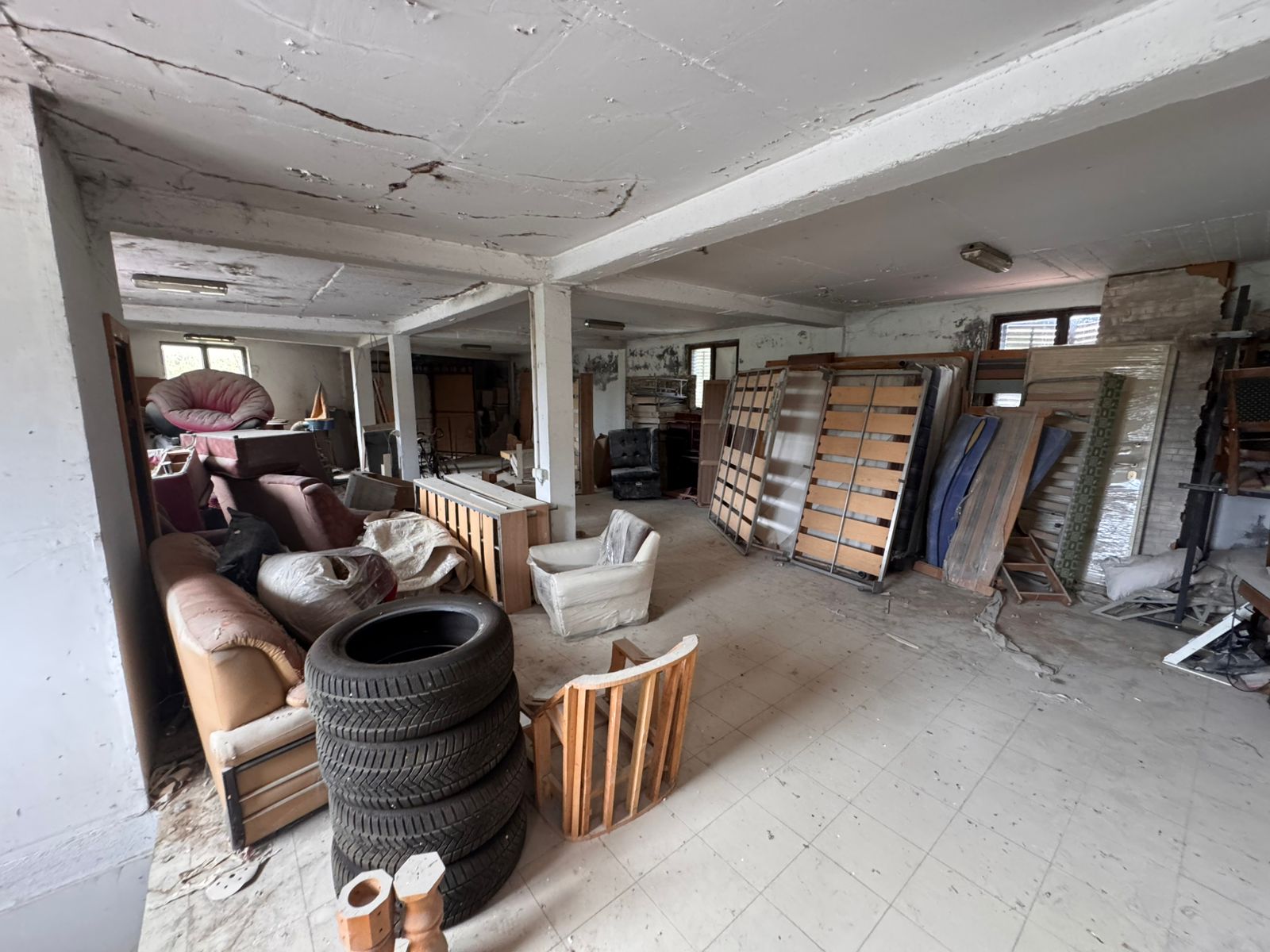 Spacious Ulcinj basement/garage with white walls, tiled floor&mdash;ideal for renovation or storage. Exclusive at immobilien.ekosphere.me by ekosphere doo.