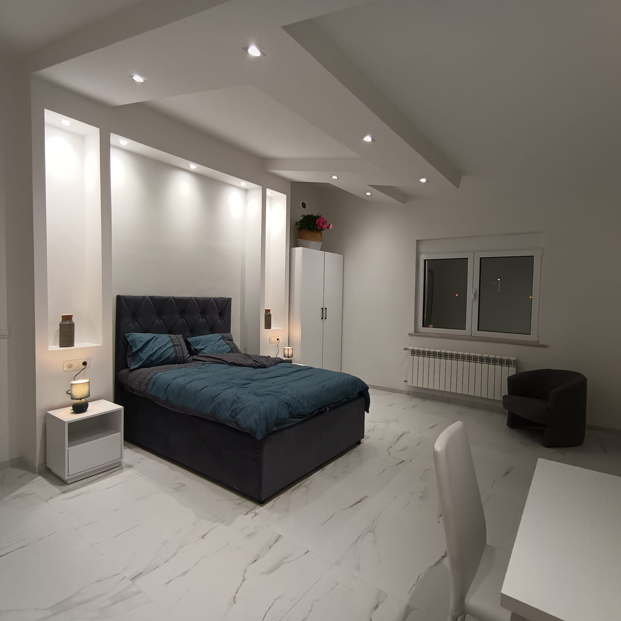 Modern Ulcinj bedroom with white interiors, stylish blue bed, office space, and premium features&mdash;exclusive at immobilien.ekosphere.me.