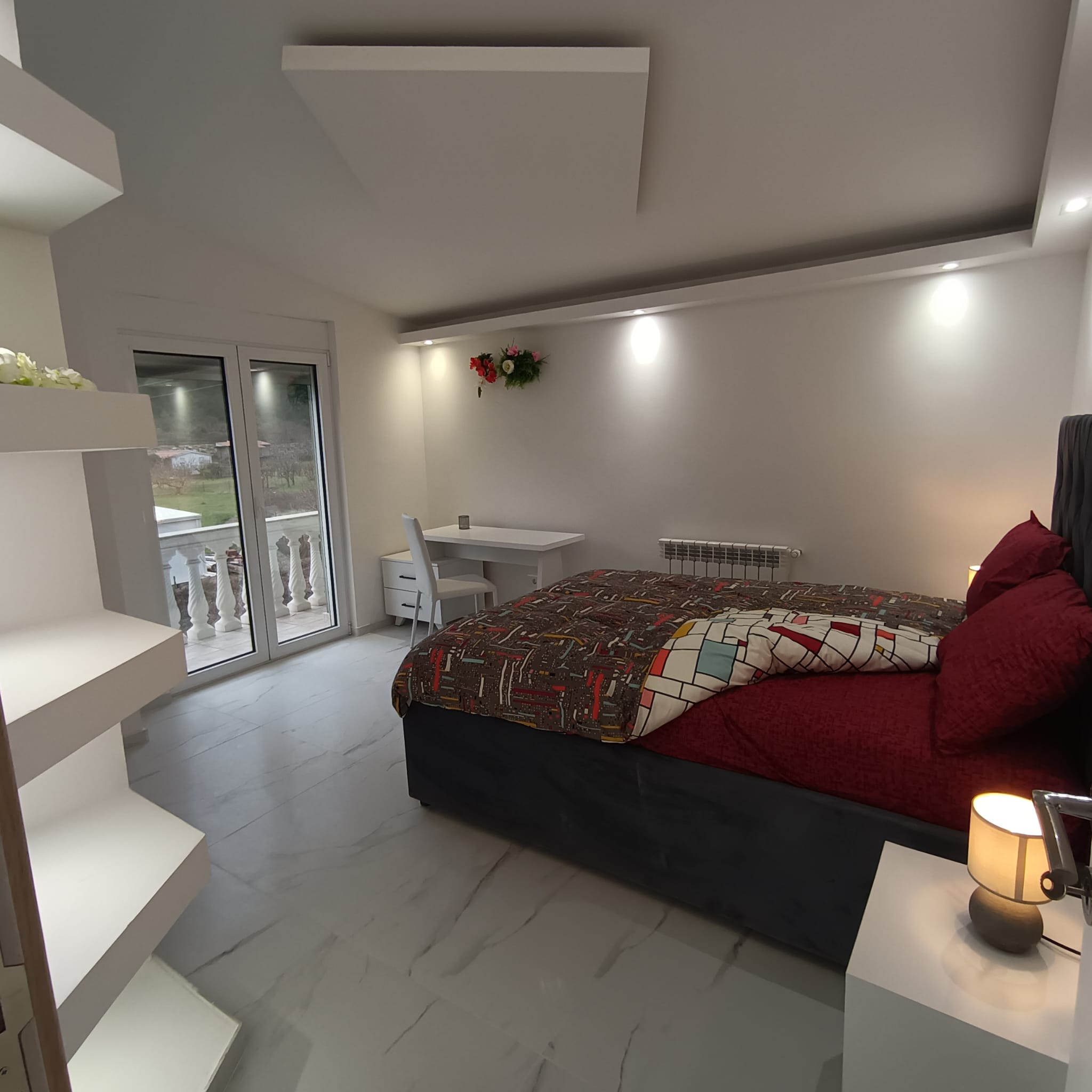 Sleek modern bedroom in Ulcinj with white interiors, stylish bed, workspace, and built-ins&mdash;exclusive at immobilien.ekosphere.me by ekosphere doo.