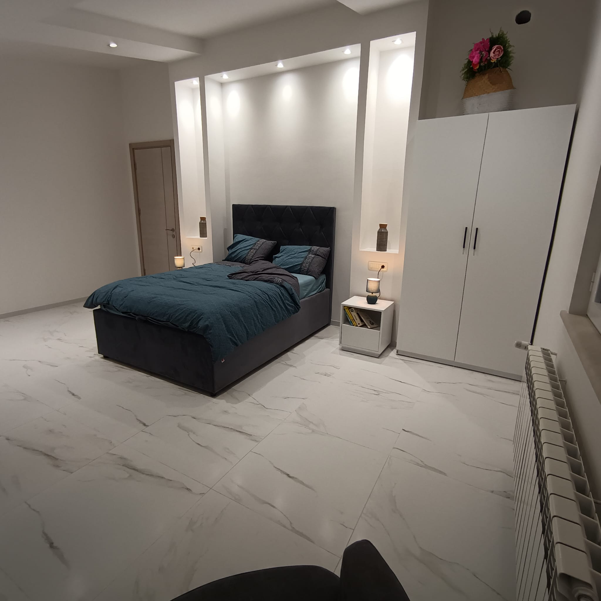 Modern Ulcinj bedroom with marble floors, elegant teal-accented bed, and premium finishes&mdash;exclusive from ekosphere doo on immobilien.ekosphere.me.